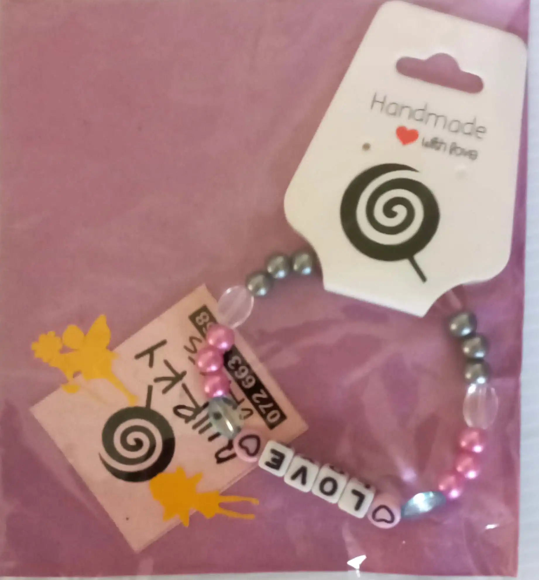 A Quirky Craft Charmed Bracelet with beads that reads love